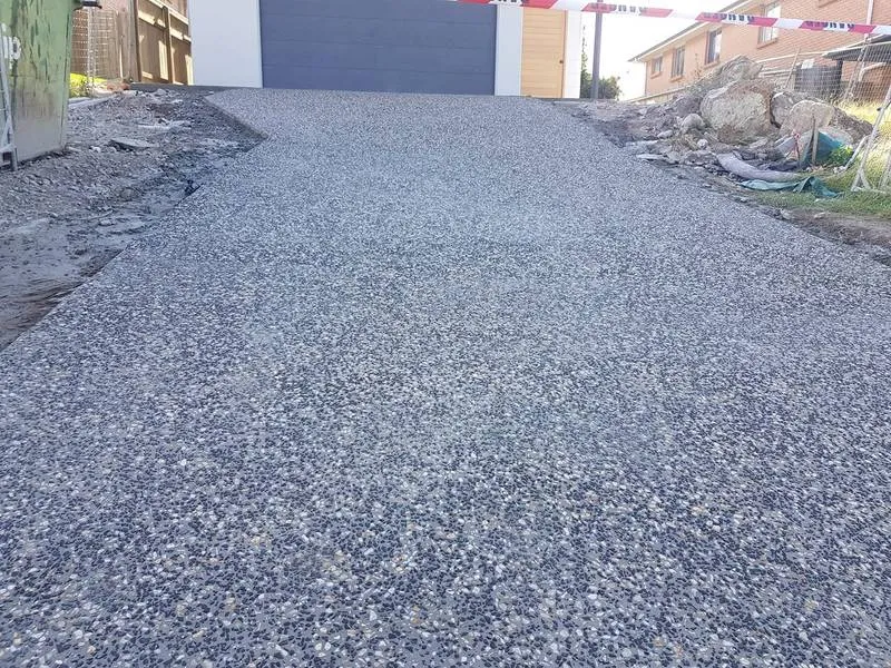 Exposed aggregate concrete driveway leading to a garage